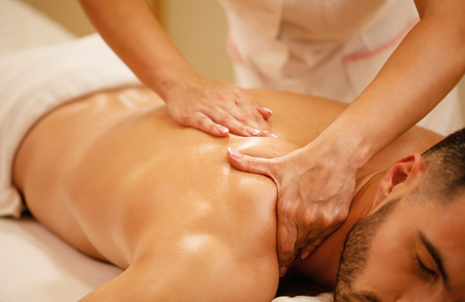 Close-up of man having back massage during spa treatment at wellness center.